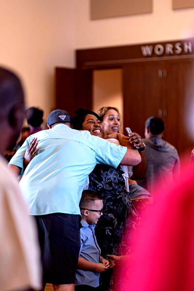 HFBC congregation members hugging during service.