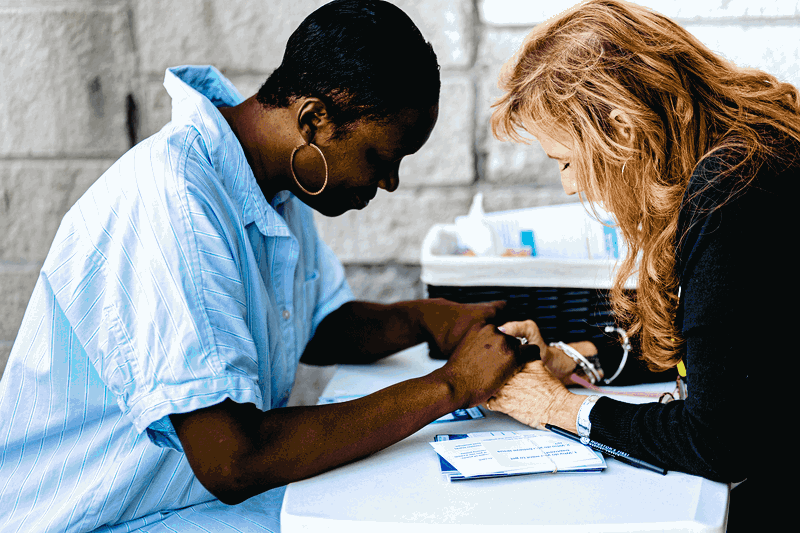 Women praying together at a table at HFBC